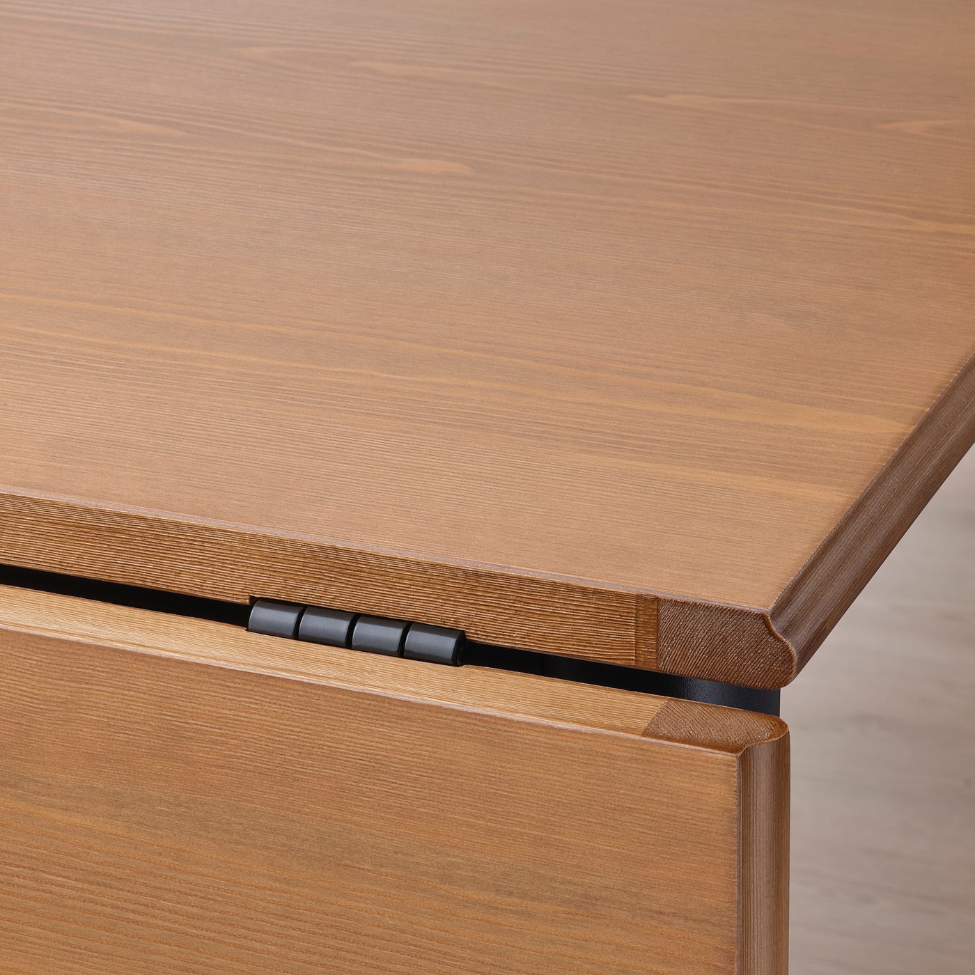 Detail view of IKEA DANDERYD pine veneer table top and hinge area